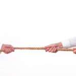 Tug war, two businessman pulling a rope in opposite directions isolated on white background